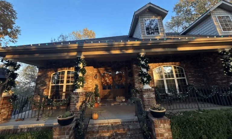 Front porch and roofline decorated with multicolor Christmas lights on a residential home